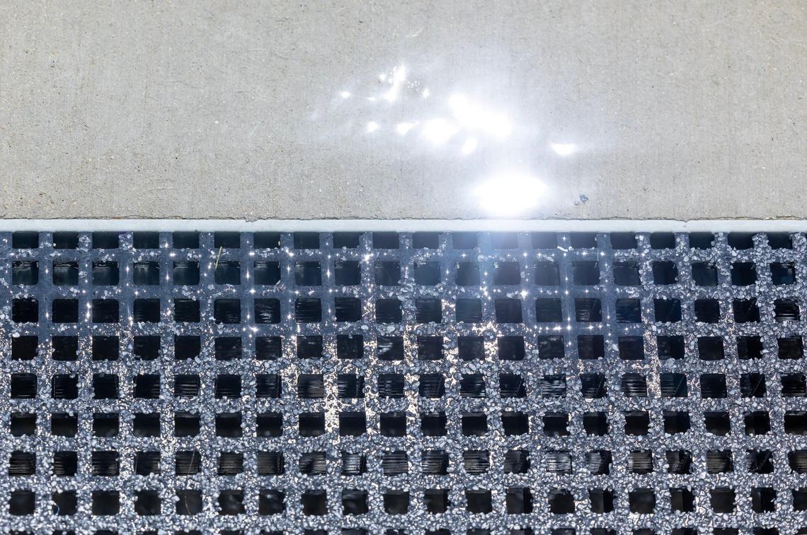 Excess water is collected in a drain to be recycled.