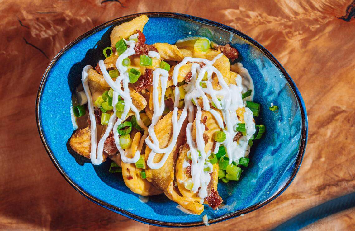 Classic Loaded Fries ($11): Sidewinder fries topped with queso, sour cream, bacon and green onions.