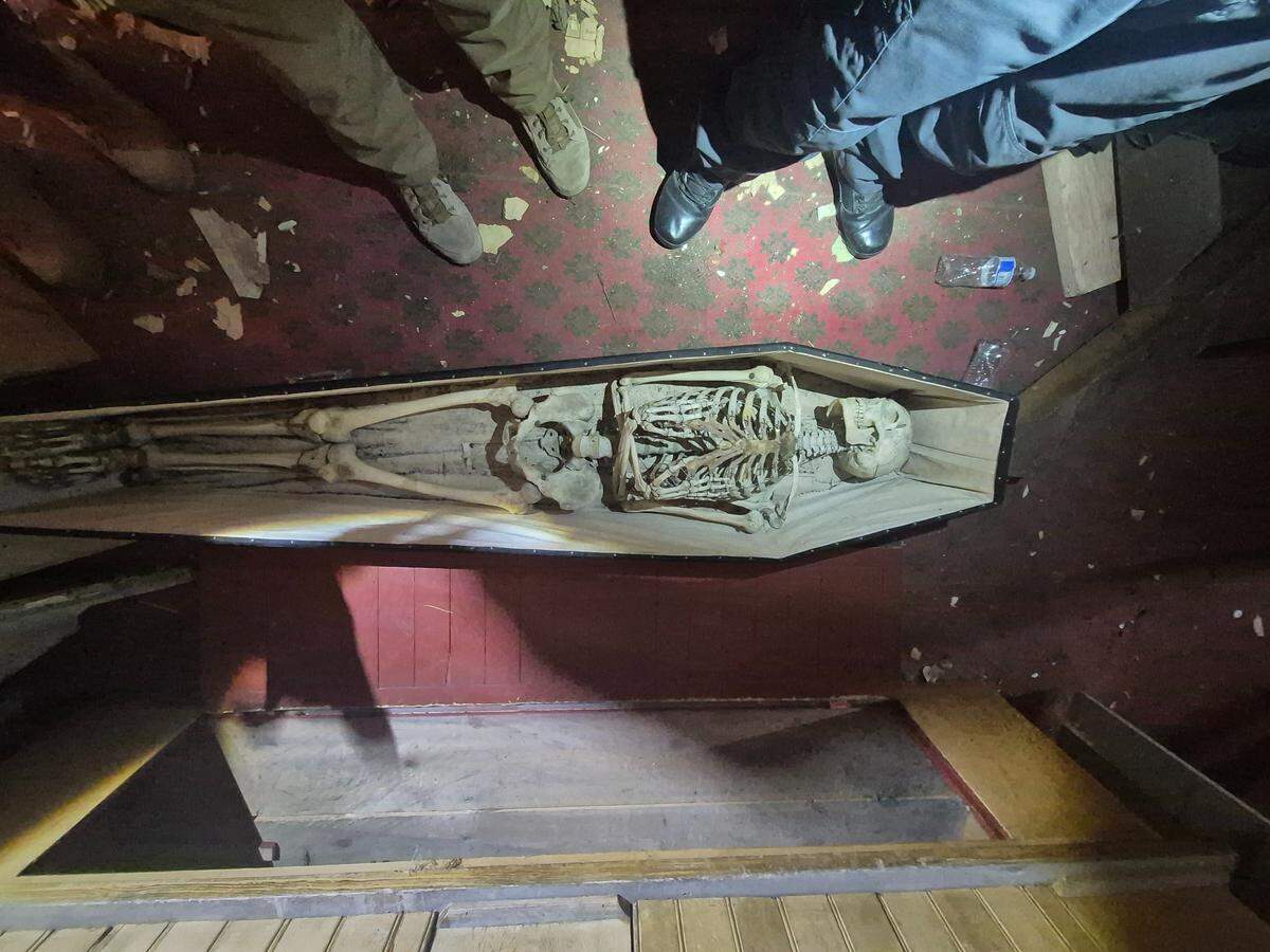A photo shows the skeletal remains found inside the hidden coffin.