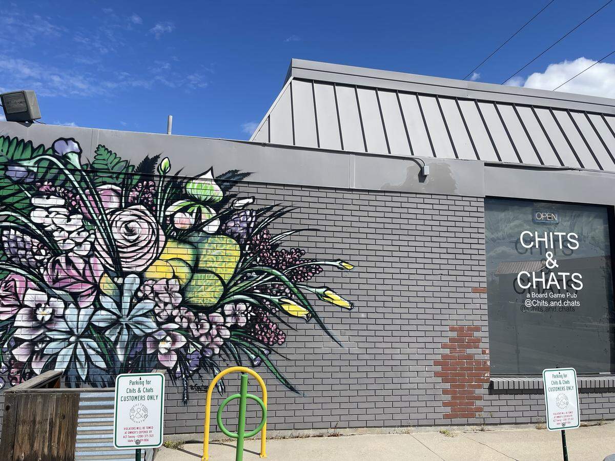 A photo of the side of Chits and Chats. This board game pub in downtown Boise is family operated and covered in local artwork.