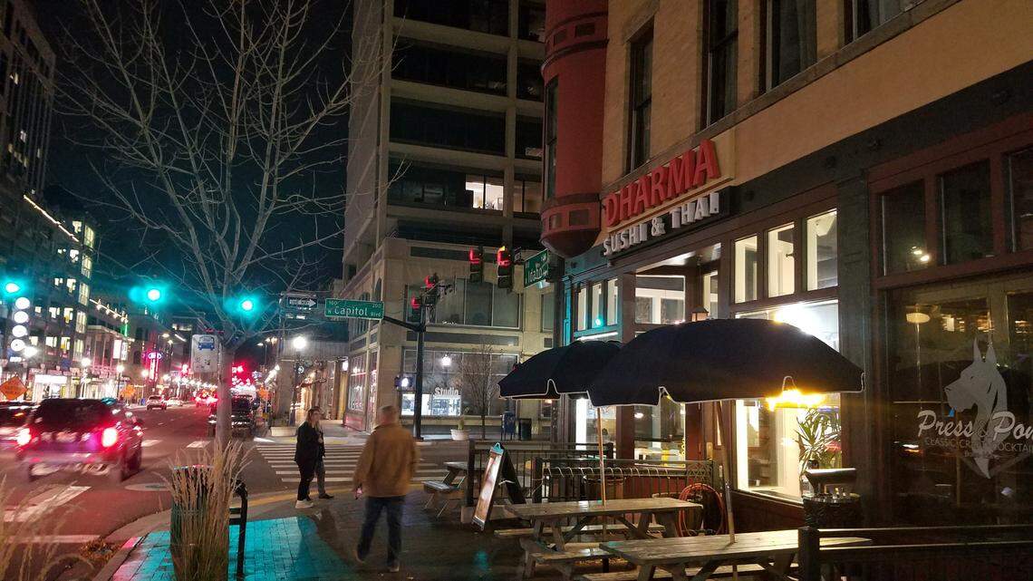 People in downtown Boise walk past Dharma Sushi & Thai.