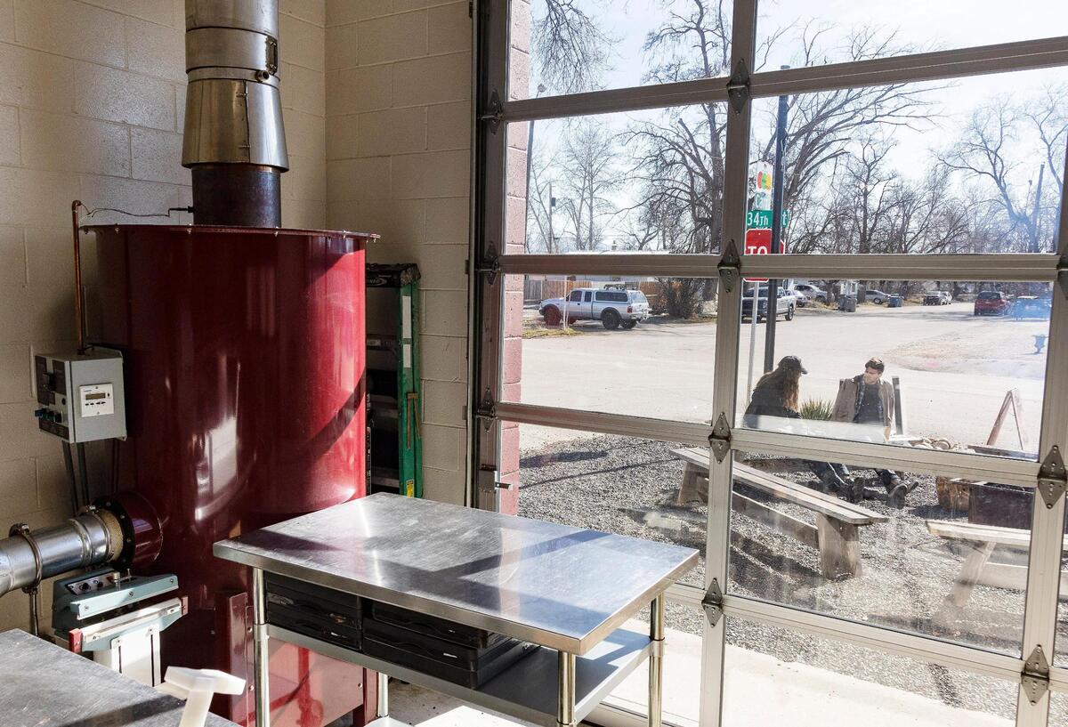 A glass garage door looks out from the coffee bean roasting area to the porch seating at Push & Pour in Garden City.
