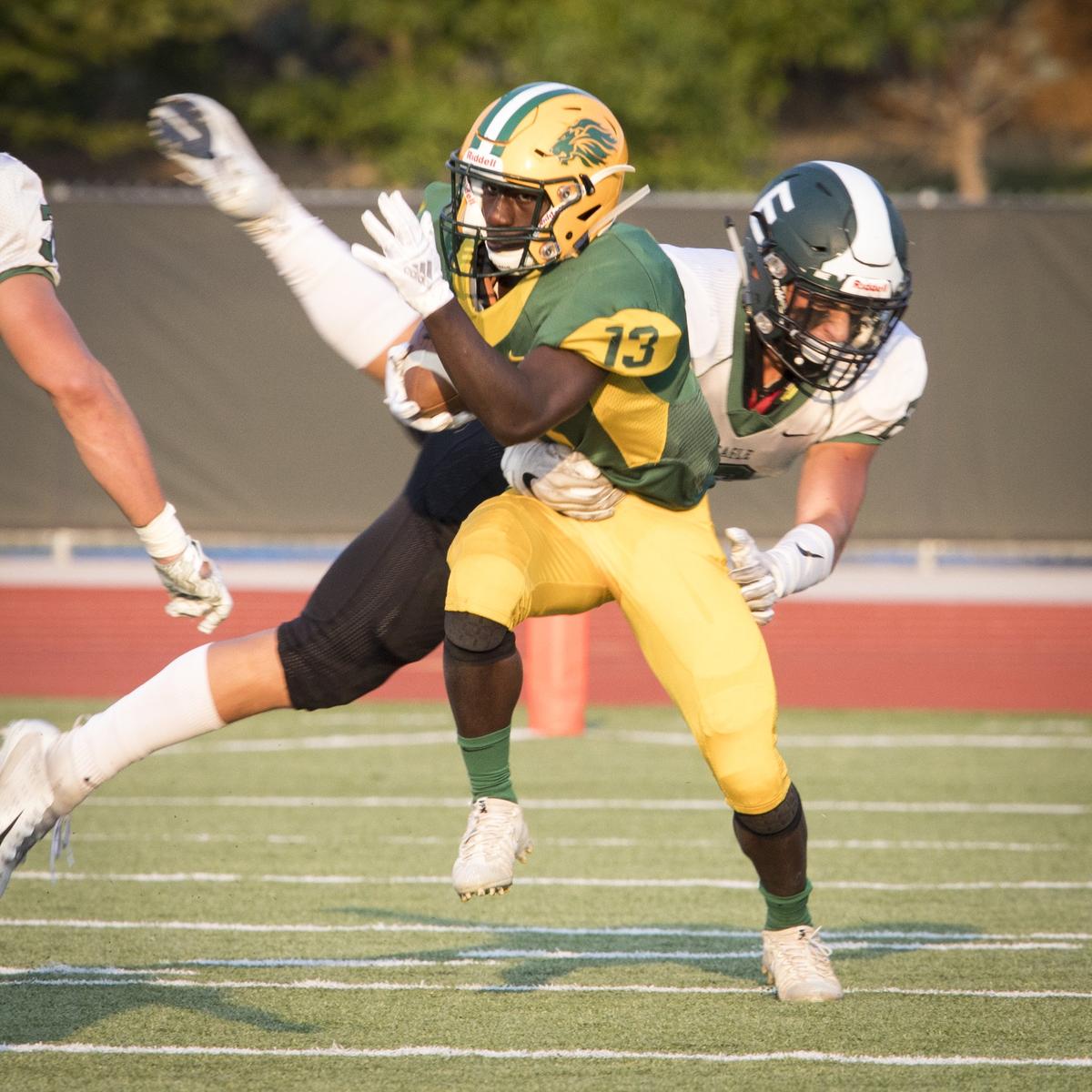 Borah running back Innocent Ndayiragije evades Eagle’s Matt Hudson during the Lions’ 42-25 win at Dona Larsen Park on Aug. 30.