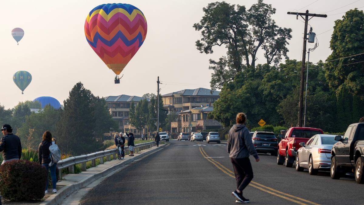 Hot air balloons fly Friday in smoky skies for the Spirit of Boise event.
