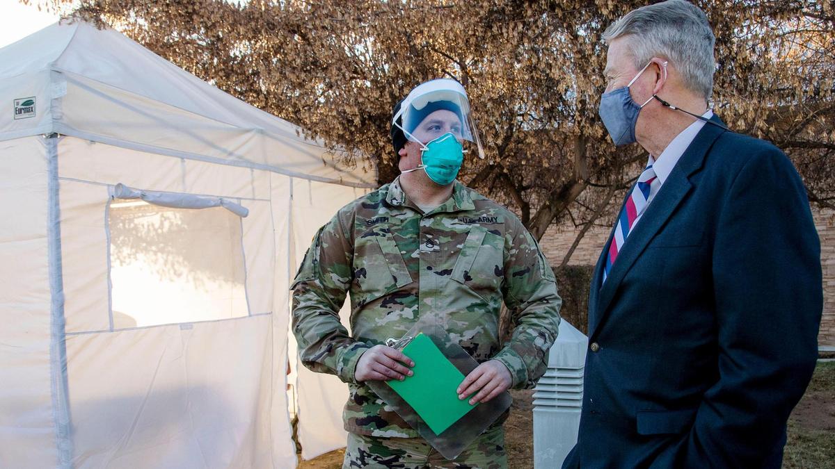 Gov. Brad Little talks with Staff Sgt. Shawn Smith, a member of the Idaho National Guard assisting health workers at Saint Alphonsus Health Plaza in Meridian. Little visited with Guard members on Dec. 3 as they collected data and administered COVID-19 tests.