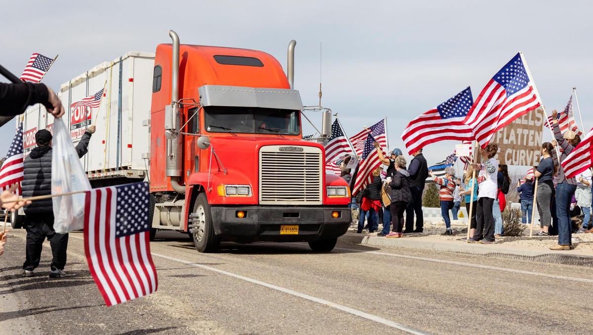 Attendees line the offramp onto Broadway Avenue from Interstate 84 in Boise to support truck drivers who are opposed to mandatory COVID-19 vaccinations.
