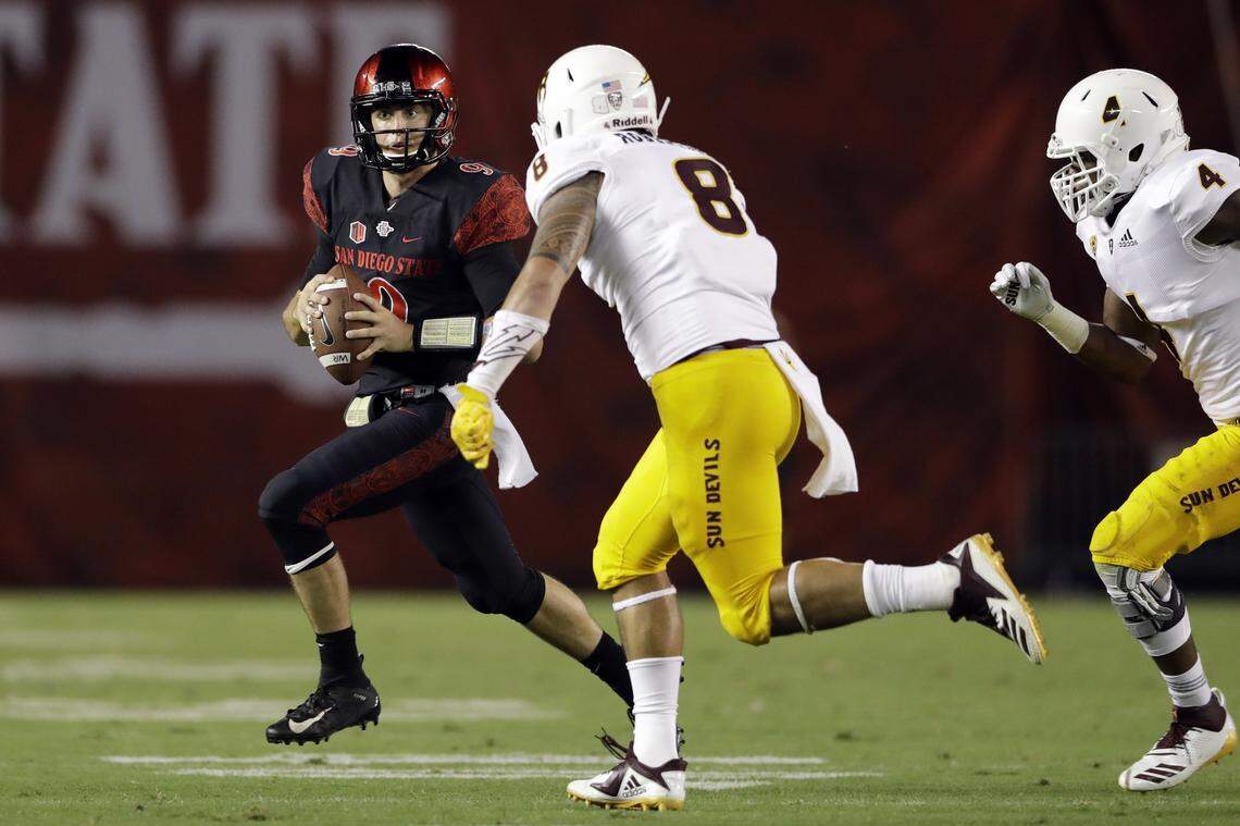 San Diego State quarterback Ryan Agnew, left, looks to pass as Arizona State linebacker Merlin Robertson defends during the first half Sept. 15  in San Diego.