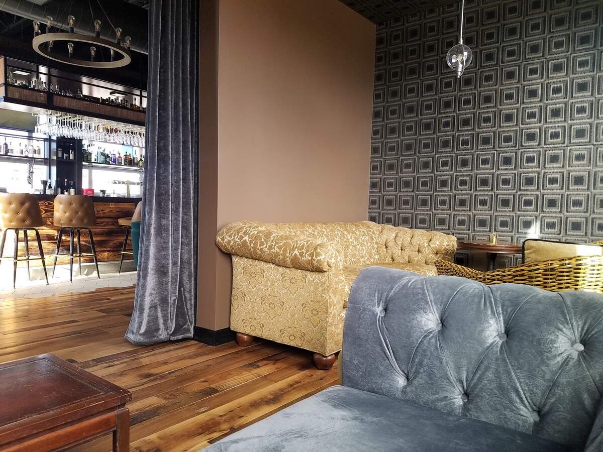 A cozy, secluded corner of the bar includes comfy furniture.
