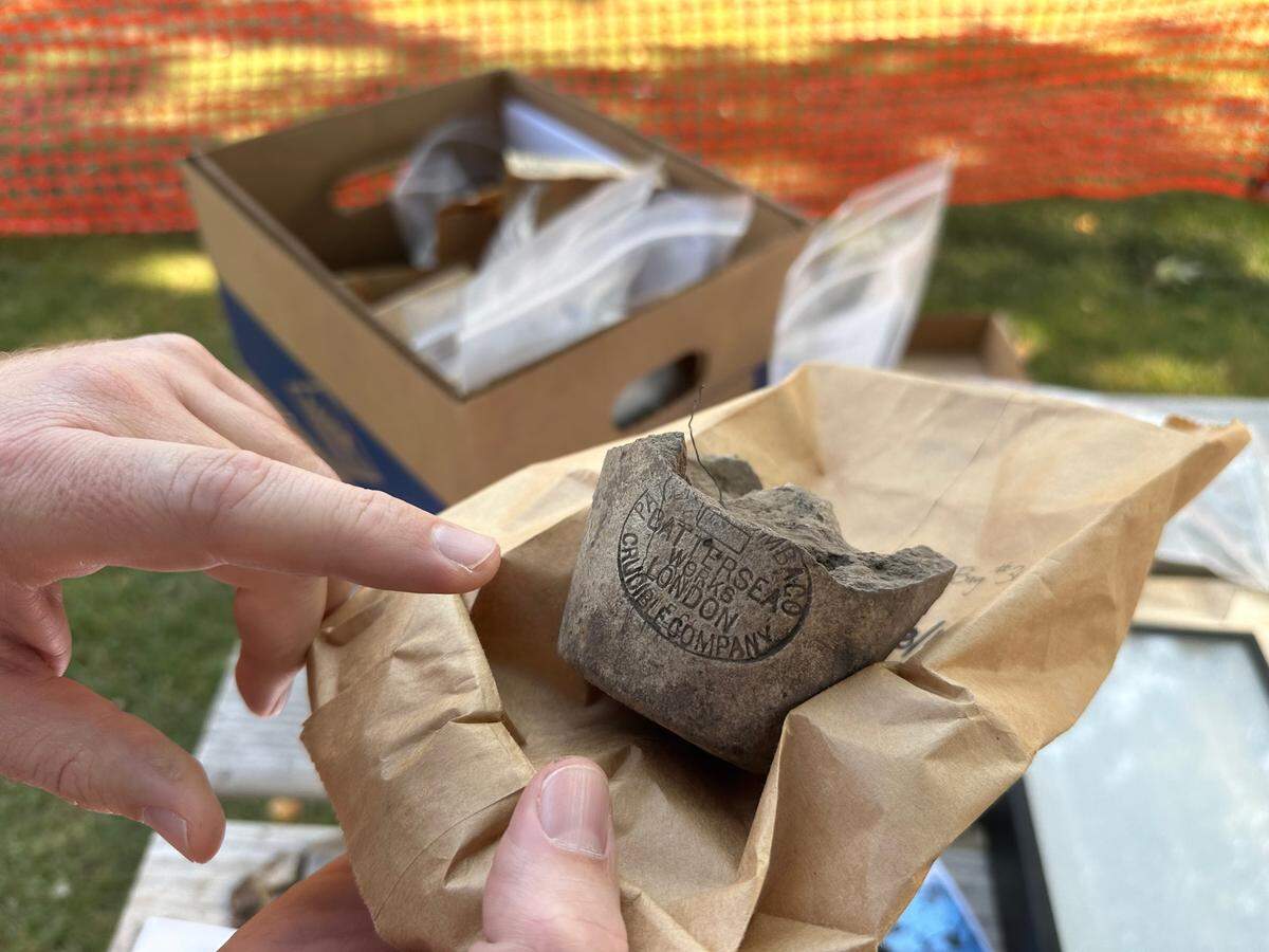 Dan Everhart, Idaho State Historic Preservation Office outreach historian, points to a maker’s mark on the base of a crucible, used to process and refine ore samples. Such maker’s marks allow historians to date the artifact based on when the company was in business.