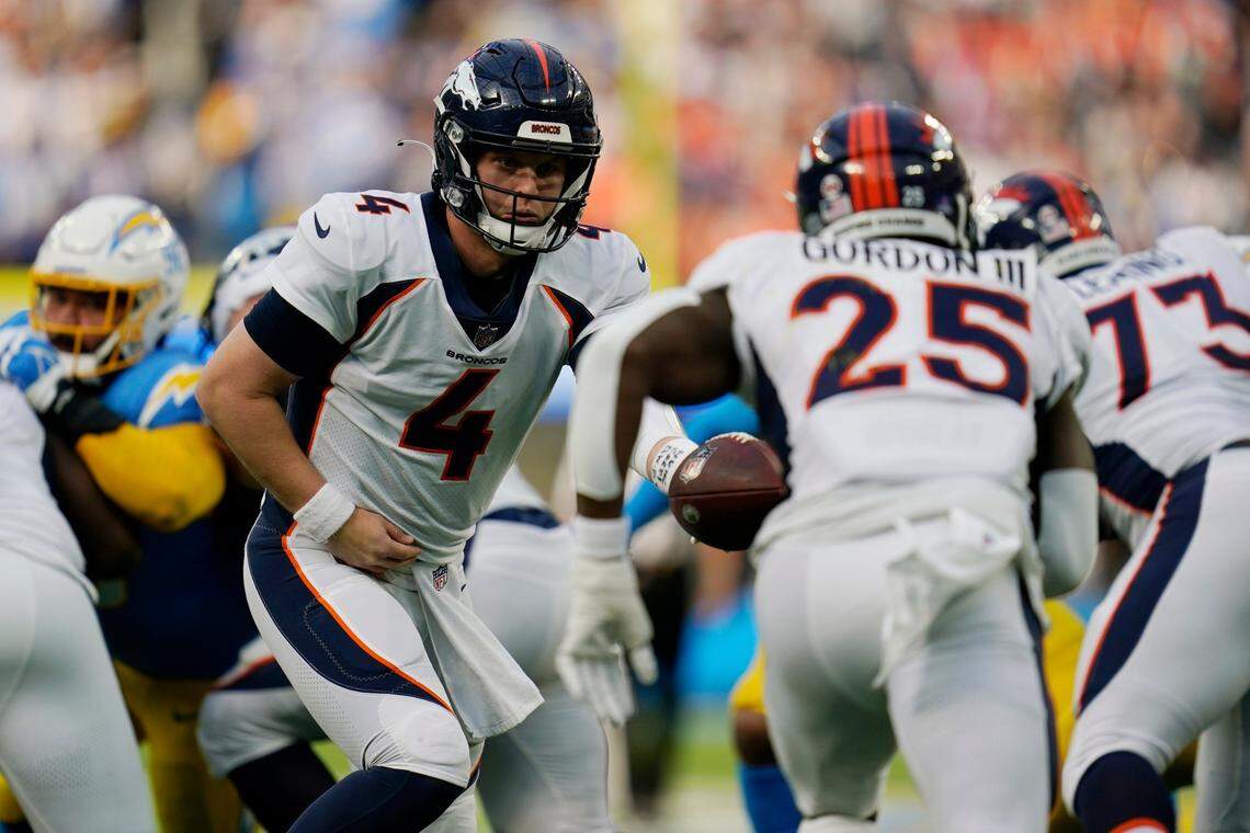 Denver Broncos quarterback Brett Rypien, left, hands off to running back Melvin Gordon in the first quarter against the Los Angeles Chargers on Sunday in Inglewood, Calif.