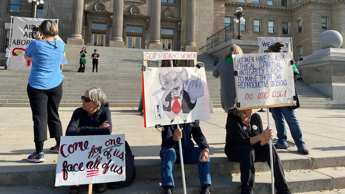 Protesters hold pro-abortion rights posters during a Women’s March rally at the Idaho State Capitol on Saturday morning.