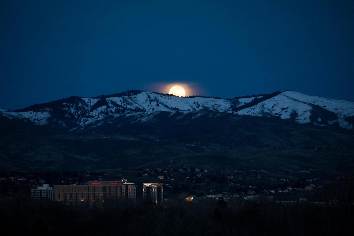 A supermoon in March 2019 is shown peaking at Boise over a mountainous skyline in this file photo. Blue moons occur when a calendar year has 13 full moons.
