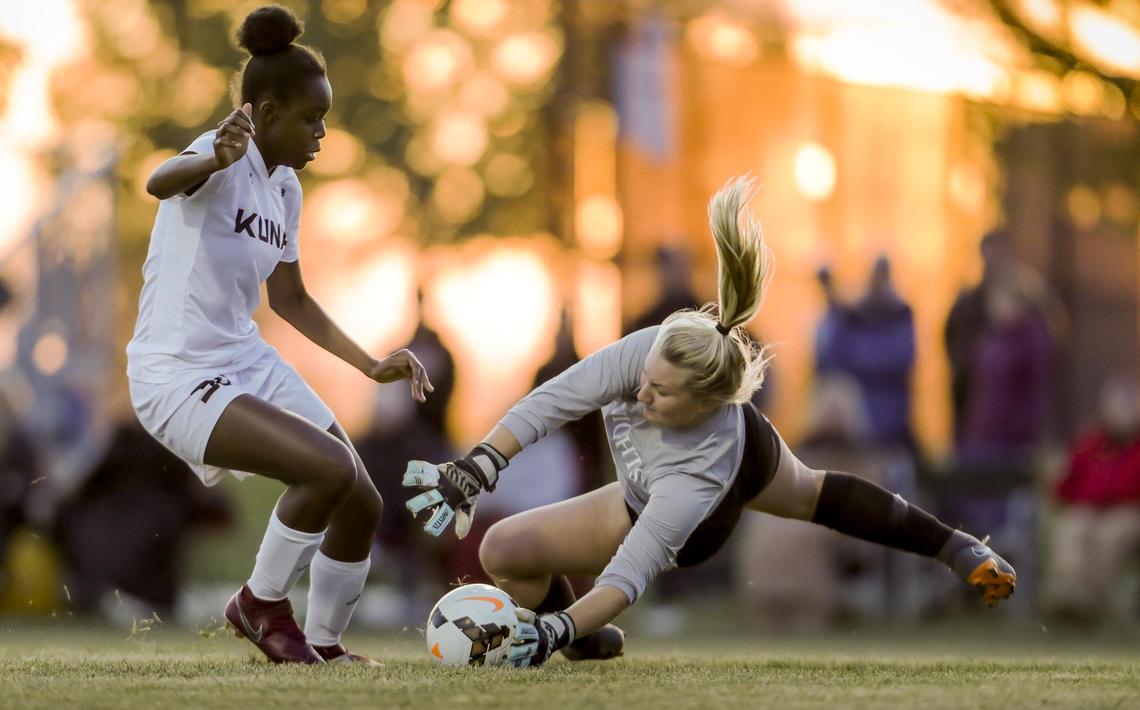 Bishop Kelly goalkeeper Natalie Phillips stops a run at goal by Kuna’s Aminah Bah in the 4A District Three girls soccer championship Thursday.
