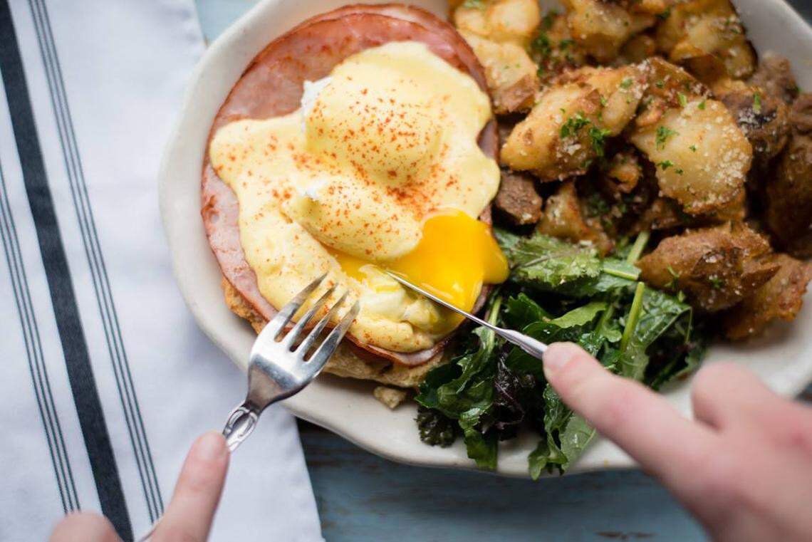 Brunch time: A poached egg tops scratch-made Eggs Betty with smoked ham and housemade hollandaise over a buttermilk biscuit with a side of potato cracklins.