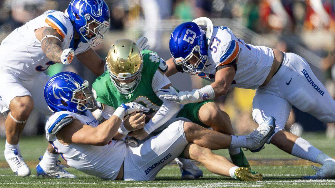 Boise State linebackers Jake Ripp and Marco Notarainni (53) tackle Notre Dame quarterback CJ Carr in South Bend, Ind., Saturday, Oct. 4, 2025.