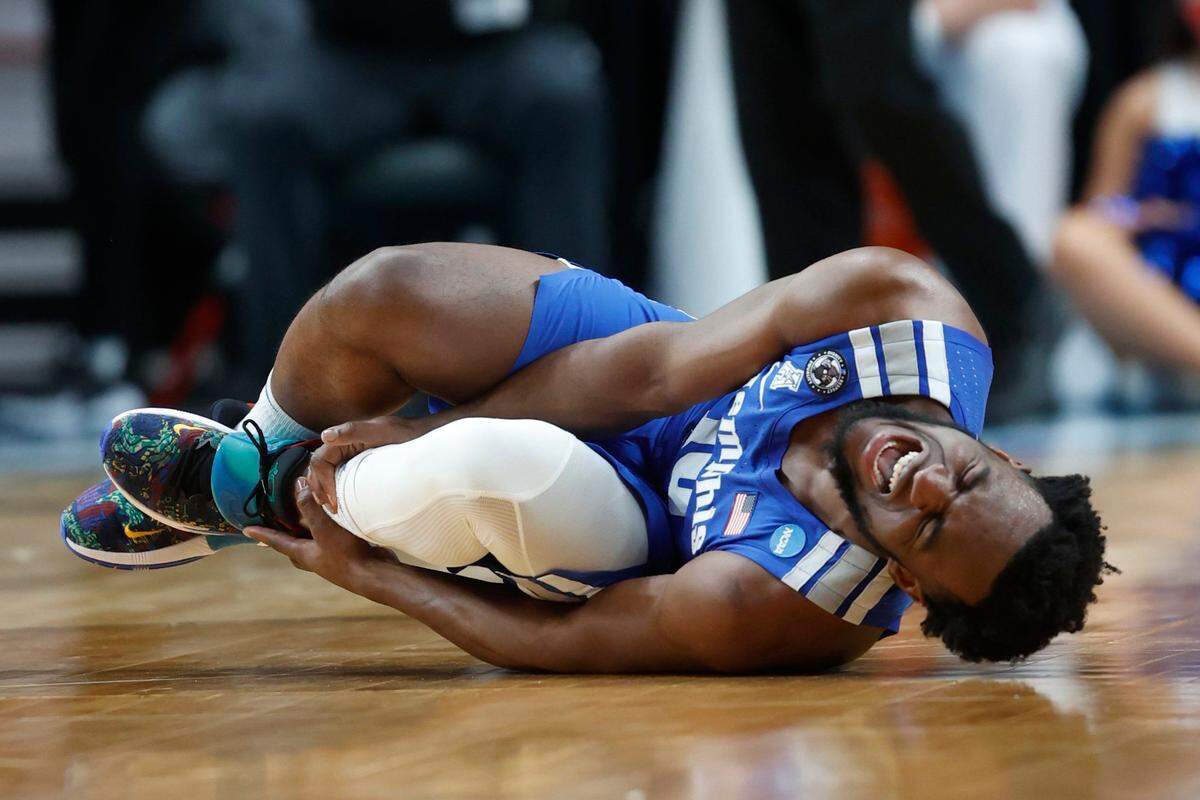 Memphis guard Alex Lomax holds his ankle after going down against Boise State during the first half of the Tigers’ 64-53 win Thursday at the Moda Center in Portland, Oregon.