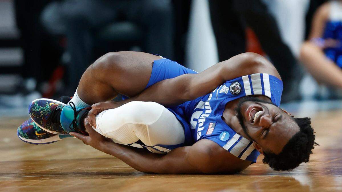 Memphis guard Alex Lomax holds his ankle after going down against Boise State during the first half of the Tigers’ 64-53 win Thursday at the Moda Center in Portland, Oregon. He returned in the second half.