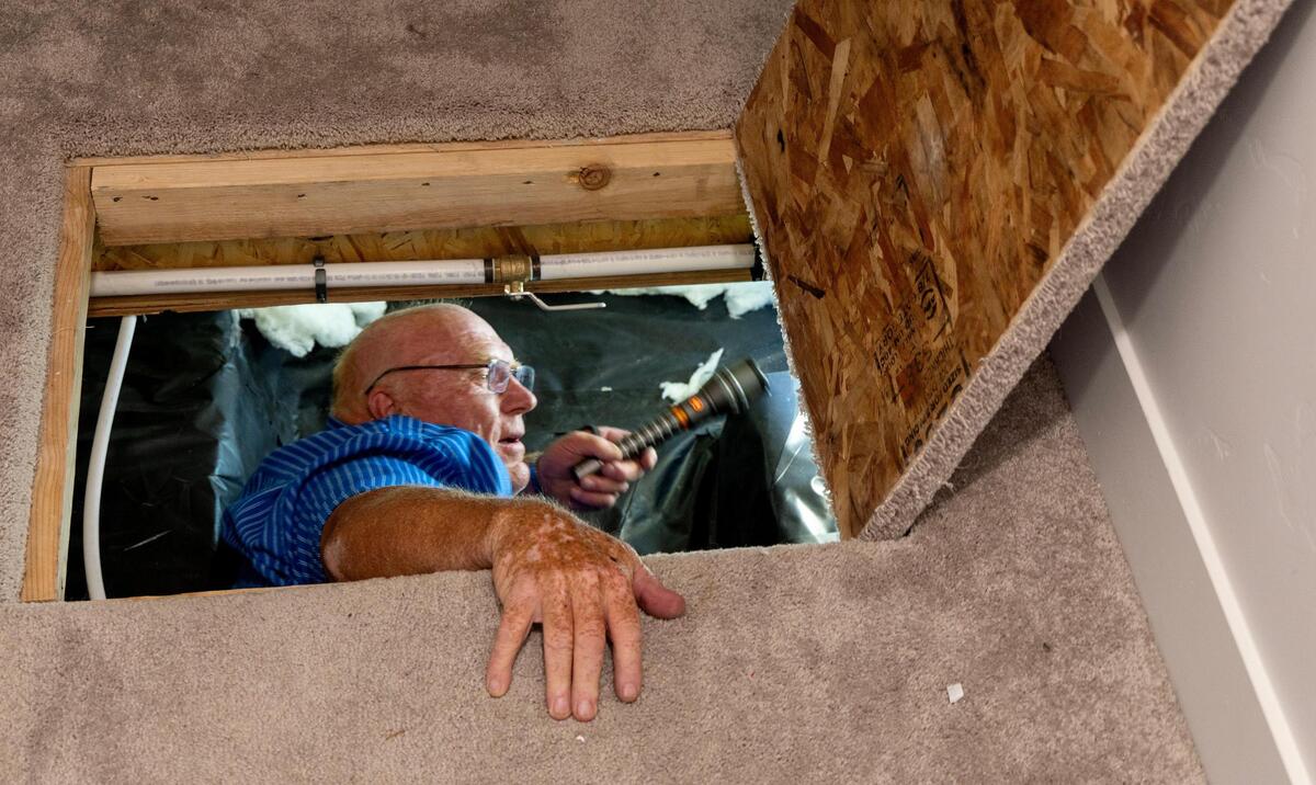Former building official David Wardell inspects the crawlspace of a home in Caldwell.