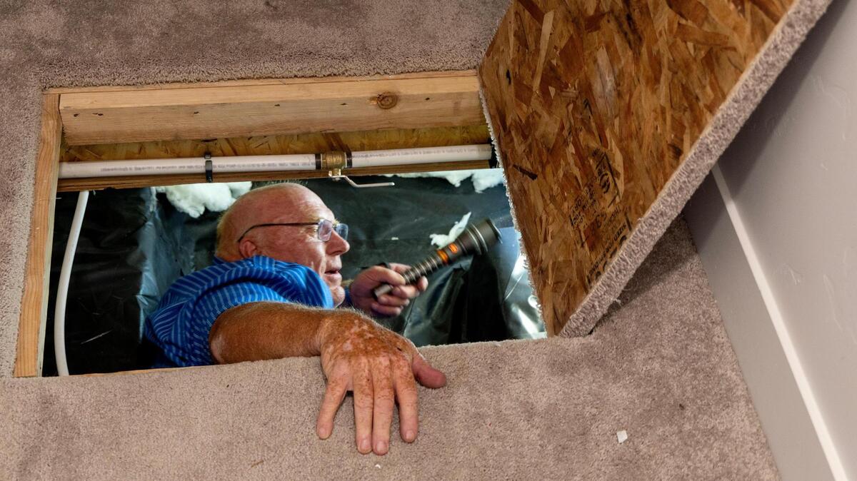 Former building official David Wardell inspects the crawlspace of a home in Caldwell.