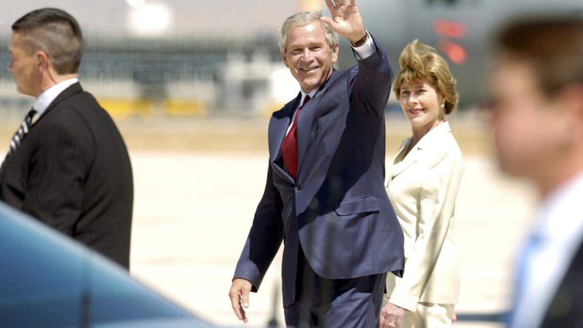 Behind a presidential limousine and flanked by Secret Service agents, President George W. Bush waves from the Gowen Field tarmac before boarding Marine One for a helicopter flight to Donnelly in 2008. The president spent only a few minutes in Boise before leaving for a short vacation at Tamarack Resort.