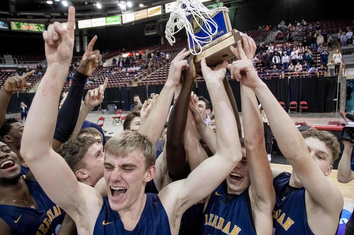Meridian celebrates with the 5A boys basketball state championship trophy after defeating Lake City 68-54 on Saturday at the Ford Idaho Center in Nampa.