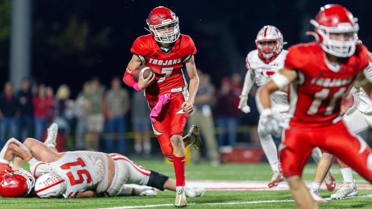 Homedale senior quarterback Dillon Fine tucks the ball and turns upfield on Oct. 6 against Weiser.