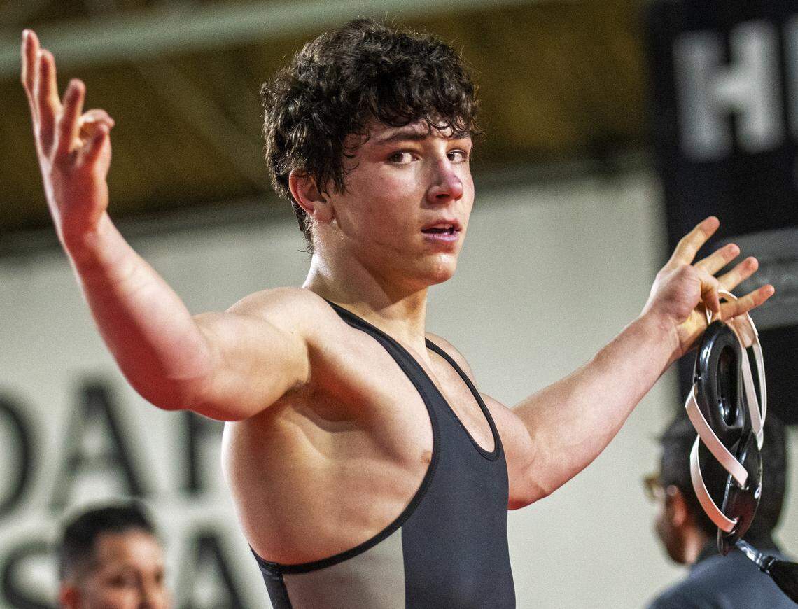 Post Falls senior Ridge Lovett holds four fingers in the air after winning his fourth state title and finishing his career 169-0 Saturday at Holt Arena. Lovett beat Centennial senior Ryan Wilson 2-1 in their 5A 145-pound championship match.