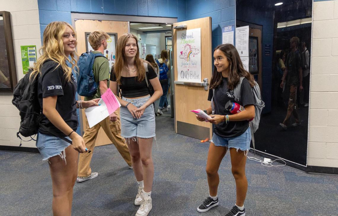 Wolf Connection student ambassadors senior Lainey Peters, left, and junior Taylor Cole, right, explain the layout of the building to new student junior Fiona Mikkelsen, center, on the first day of school Wednesday at Timberline High School. Mikkelsen is an exchange student from Denmark.