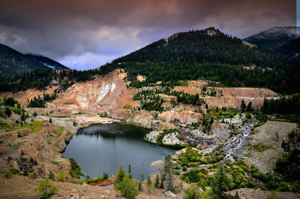 This is the abandoned Yellow Pine Pit at the Midas Gold site. The East Fork of the South Fork of the Salmon River flows into it. The high walls of the pit are a barrier to fish trying to reach native spawning grounds. Midas Gold says it will allow the pit to fill with sediment, then install a drain upstream on Blowout Creek to reduce sediment inflows, then rebuild the natural channels of the East Fork to allow fish migration to return.