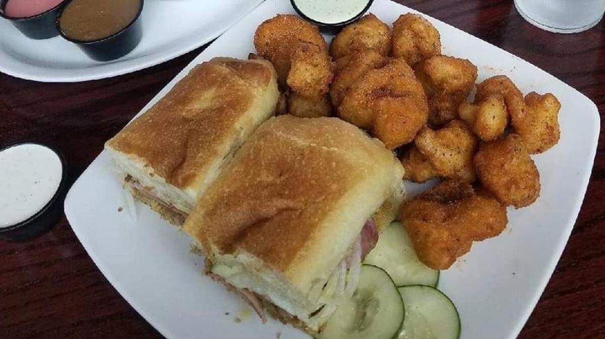 The Cubano Sandwich ($11) at Brixx includes pulled pork, ham, onions, swiss cheese, creamy mustard and house-made pickles, all on toasted village bread from Zeppole Baking Co. On the side are Veggie Wings, marinated cauliflower in tempura batter.