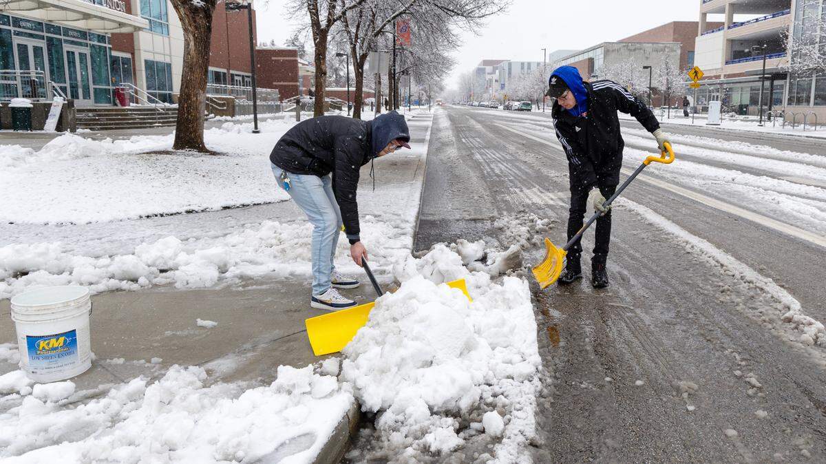 Boise State University events and operations staff members Austin Waynetska and Will Merdgen shovel snow on campus Thursday. More than 2 inches of snow fell in the Boise-area valley, with larger amounts of snow accumulating at higher elevations.