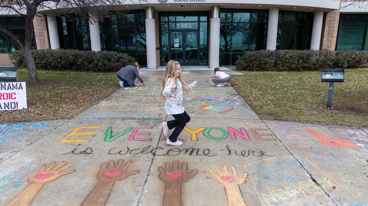 People gathered at the West Ada School District office in Meridian to chalk the words “Everyone is welcome here,” in this March file photo.