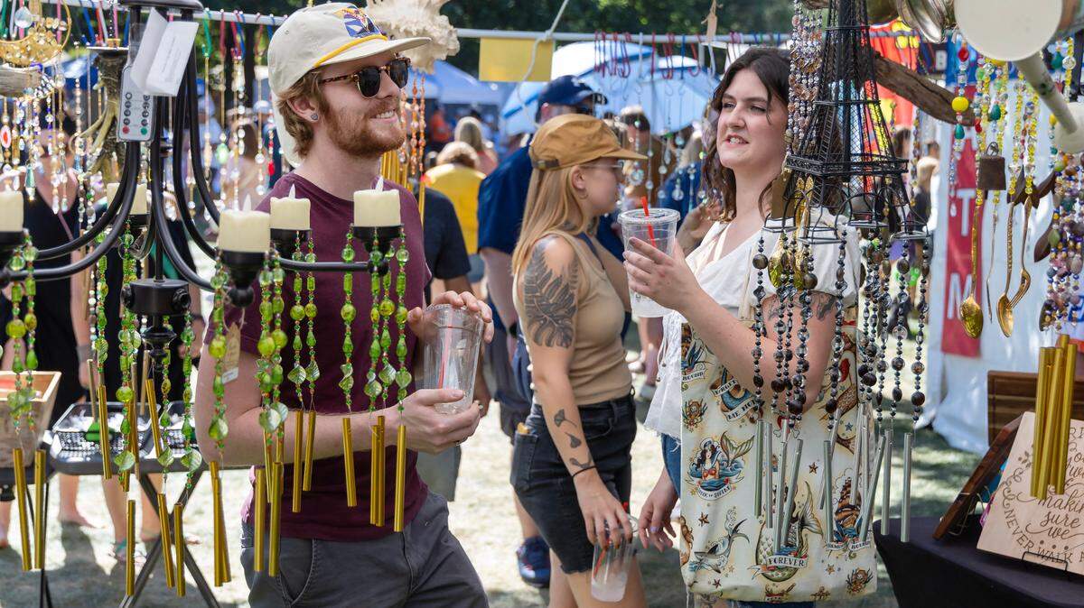 Craig Macomb and Keely Manion look at wind chimes inside the Wind Dreamer vendor booth during the Hyde Park Street Fair held at Camel’s Back Park in Boise, Saturday, Sept. 16, 2023. Wind Dreamer is a Meridian based store specializing in handmade wind chimes made with repurposed materials.