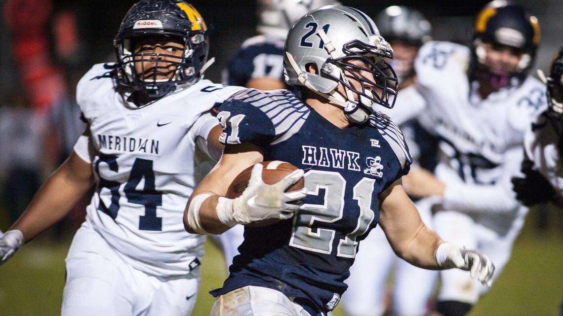 Skyview’s Tyler Crowe scampers past Meridian’s Colby Oskolkoff as part of his 457-yard rushing night Friday. The Hawks beat Meridian 70-50 to clinch a berth in the 5A state playoffs.