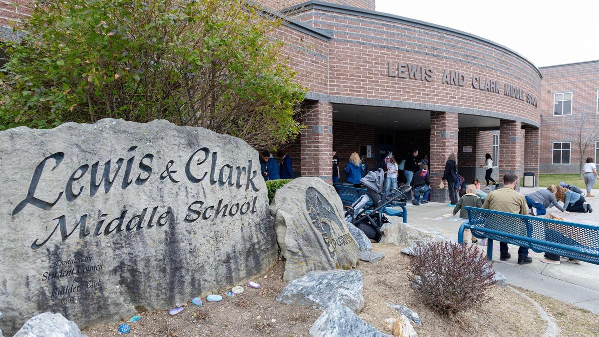 People gather Lewis and Clark Middle School on Sunday.