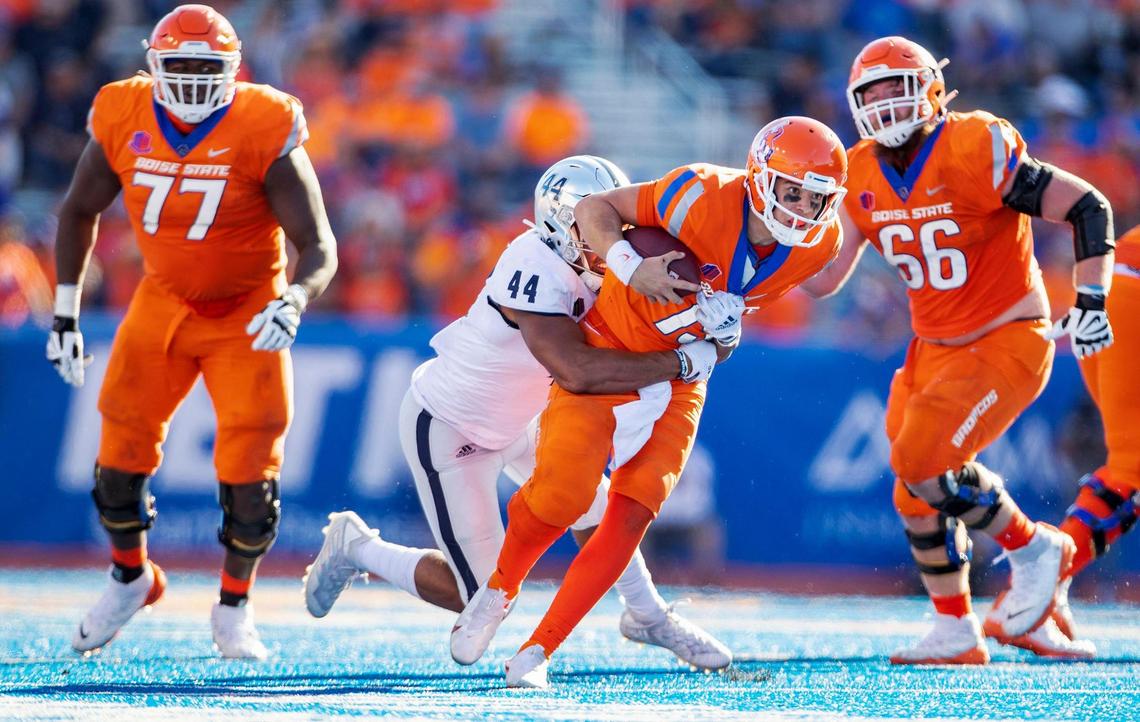Boise State quarterback Hank Bachmeier gets dragged down by Nevada defensive end Daniel Grzesiak on Saturday. The Wolf Pack sacked Bachmeier six times.