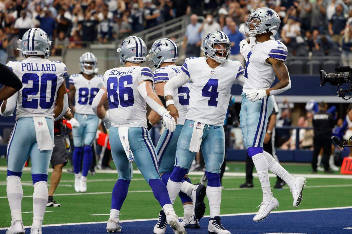 The Dallas Cowboys’ Tony Pollard, from left, Dalton Schultz, Dak Prescott and Cedrick Wilson celebrate a touchdown catch made by Wilson in the third quarter of the Cowboys’ 36-28 win over the Carolina Panthers on Sunday in Arlington, Texas.