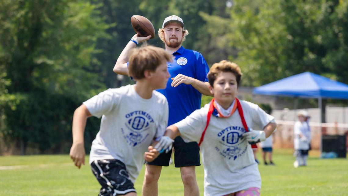 Boise State wide receiver and Borah High graduate Austin Bolt throws the ball to children participating in the Optimist Youth Football Kids Skills Camp on Saturday in Boise.