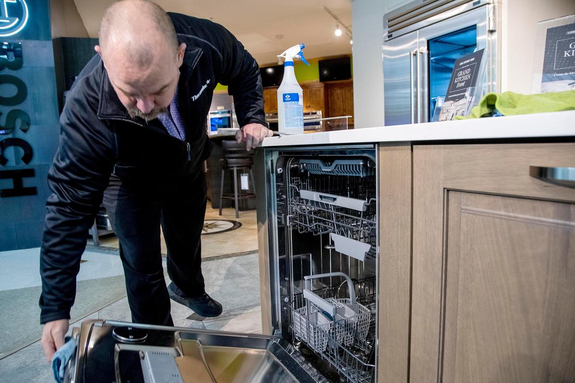 RC Willey employee David Brown disinfects surfaces after customers shop for appliances at the Meridian furniture store.