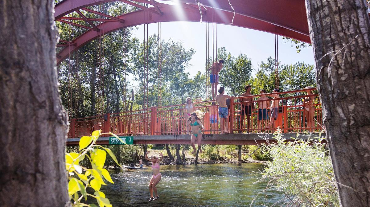 People jump from Baybrook Bridge over the Boise River on July 26, 2022. The bridge is a popular spot for splashing down every summer, but city code states that jumpers must land in the water at least 50 feet from floaters.
