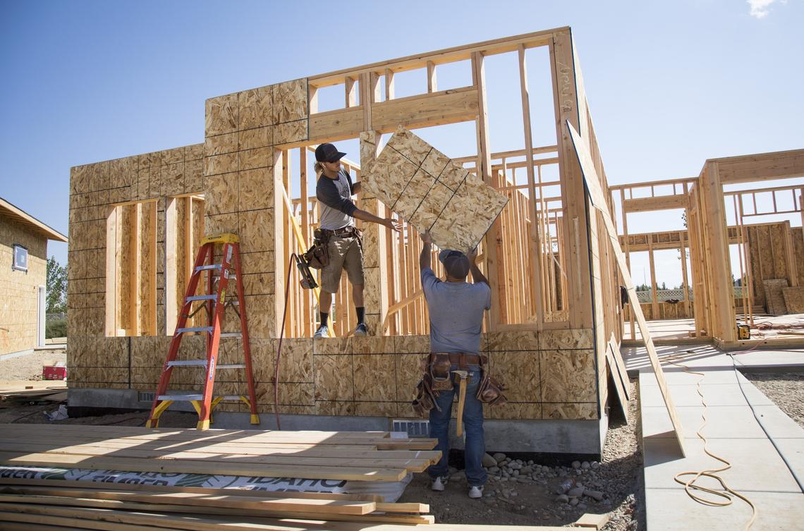 Framers Dennis Weaver, right, and Randon Gyer hang oriented strand board, or OSB, on the exterior of a Tradewinds house. The boards are a frequent target of construction thefts.