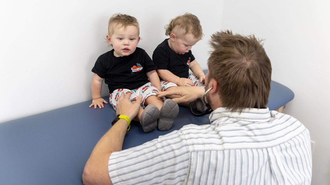 Dr. Brian Birch meets with 1-year-old twin patients at his practice, Treasure Valley Children's Clinic, in Meridian, Aug. 12, 2025.