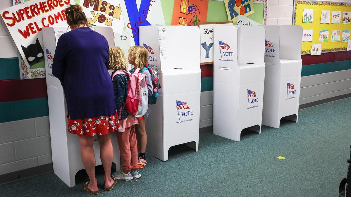 Leslie Hayes votes with her twin daughters Adelayde and Zoey, 7, who watch with abundant curiosity, Tuesday, May 17, 2022, at Ada County Precinct 1909 at Shadow Hills Elementary in Boise.