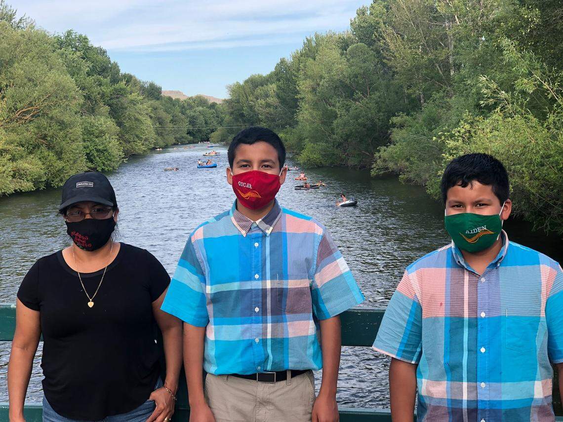 Elizabeth Barrios and her sons Oscar, 13, and Aiden, 11, pose for a masked picture overlooking the Boise River. The two boys will be attending Boise School District online this year because of the coronavirus risk, even if administrators decide to open in person. Many Latino families in Idaho are wondering if they should make the same decision.