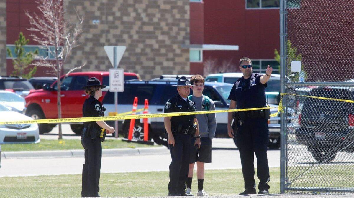 Police stand with a youth outside Rigby Middle School following a shooting there earlier Thursday, May 6, 2021, in Rigby, Idaho. A district judge ordered the county release records related to the shooting to East Idaho News. (AP Photo/Natalie Behring)