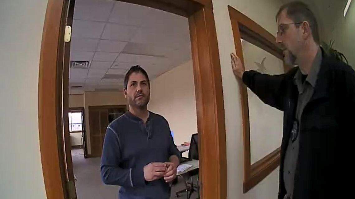 Scott Rhodes, left, speaks with Sandpoint police Officer Spencer Smith and Detective Mike Aerni, right, on Dec. 1, 2018, after Rhodes was identified as the man who distributed racist propaganda at Sandpoint High School.