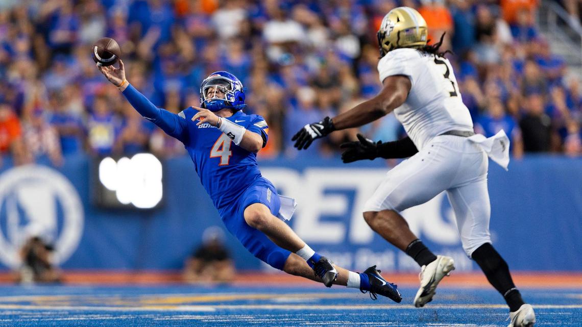 Boise State backup quarterback Maddux Madsen sails a pass while falling away from UCF defensive end Tre’Mon Morris-Brash in the fourth quarter Saturday at Albertsons Stadium.
