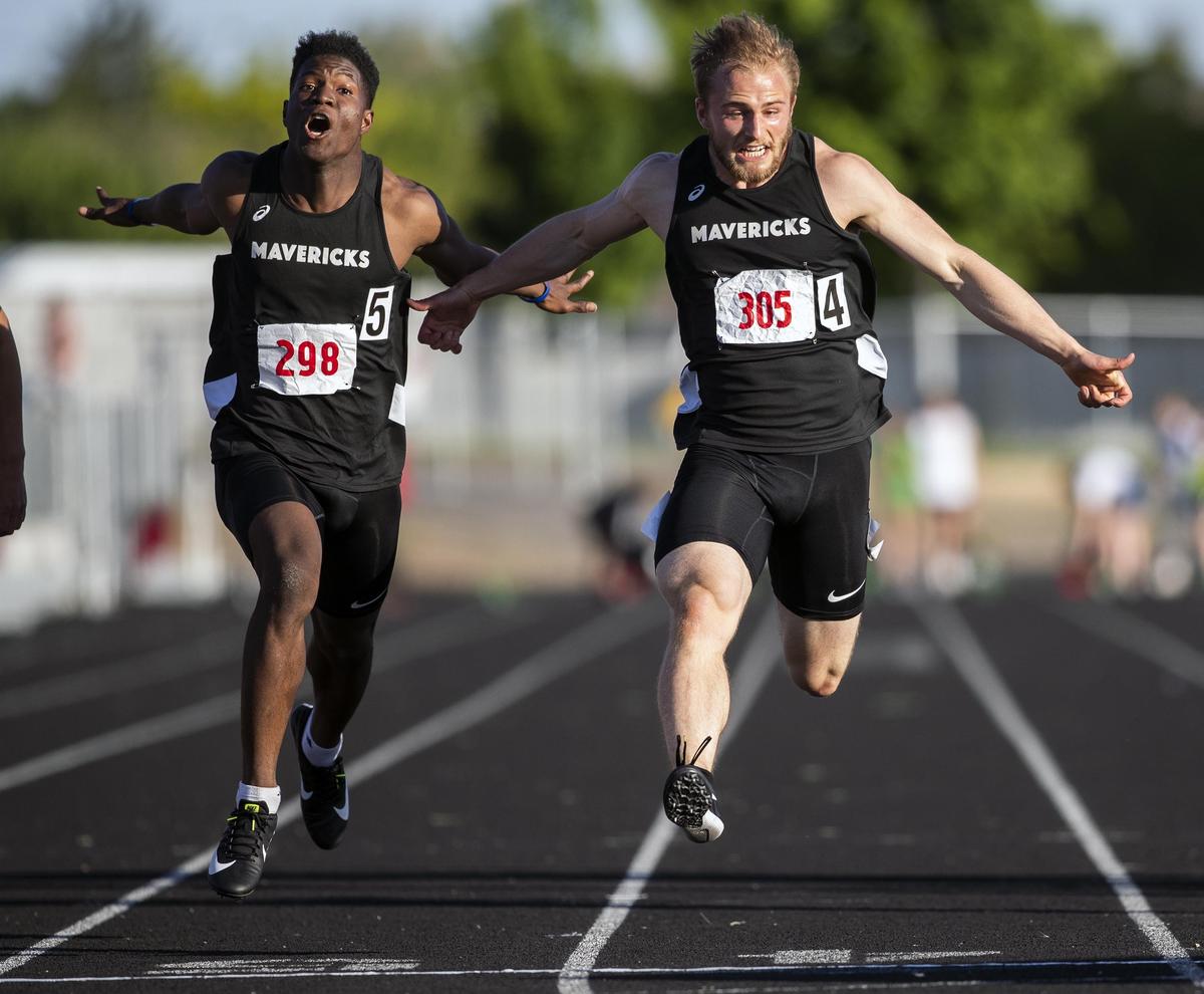 Mountain View’s Magnus Hemingway, right, lunges ahead for the victory in the 100-meter dash at last year’ 5A District Three track meet.