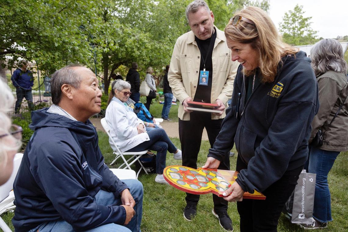 Producer Jill Giles, right, meets with a guest to learn more about his antique punchboard at the Idaho Botanical Garden in Boise on Tuesday.