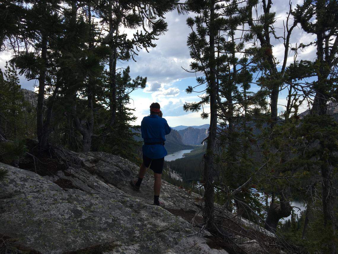 Luke McIntosh takes a photo of Ship Island Lake and the neighboring 1,000-foot towering cliffs in the Bighorn Crags of Idaho in August 2019.